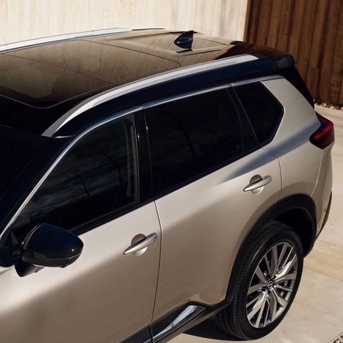 Vue extérieure du Nissan X-Trail Hybride rechargeable stationné devant une maison moderne